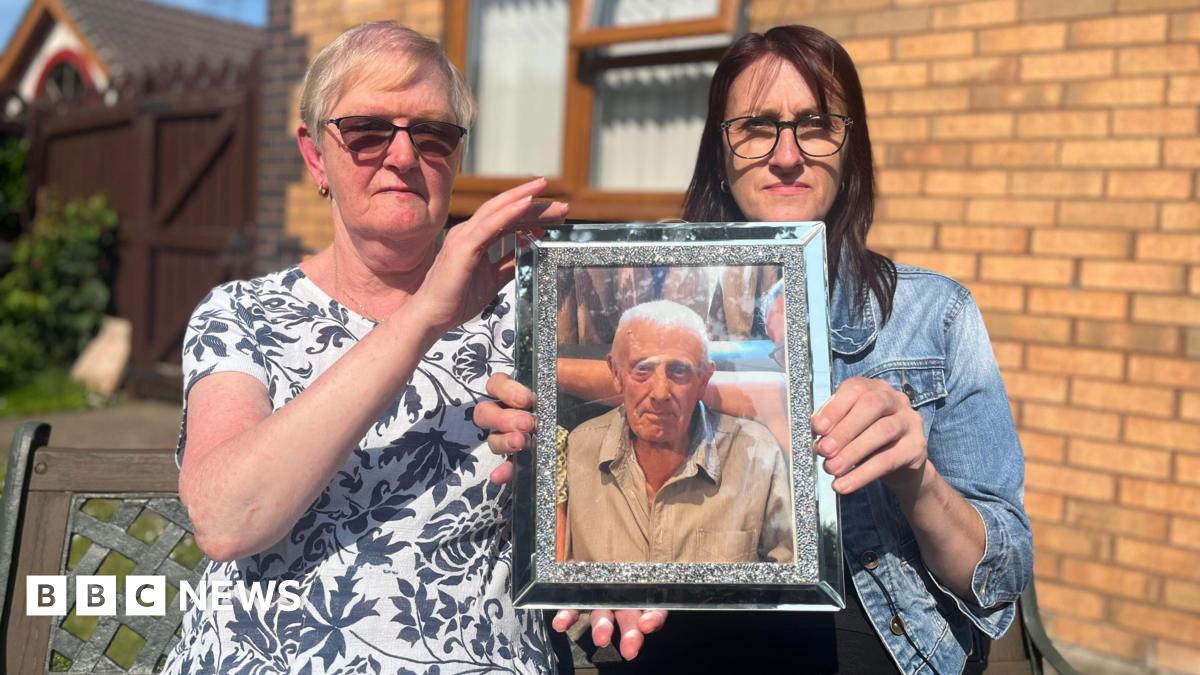 A black and white picture of a man in military uniform. He is smiling at the camera and has a badge on his beret