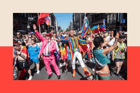 SOPA Images via Getty People celebrate at Budapest pride, some are wearing bright clothing and waving flags