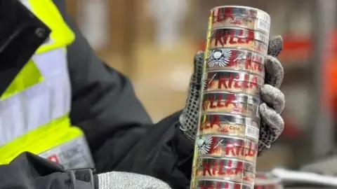 Kent Trading Standards Gloved hands hold a stack of tubs of nicotine pouches labelled with the word Killa