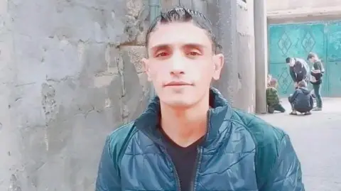 Family handout Ahmed Alhasant when he was a healthy weight is pictured in a dark green jacket by a wall  