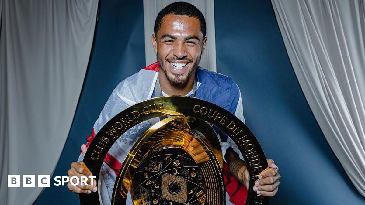 Chelsea defender Levi Colwill smiles as he poses with the Club World Cup trophy