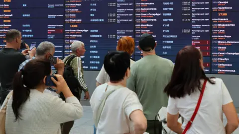 EPA/Shutterstock Passengers examine departure table waiting their flights at Sheremetyevo International Airport outside Moscow, Russia, 07 July 2025. 