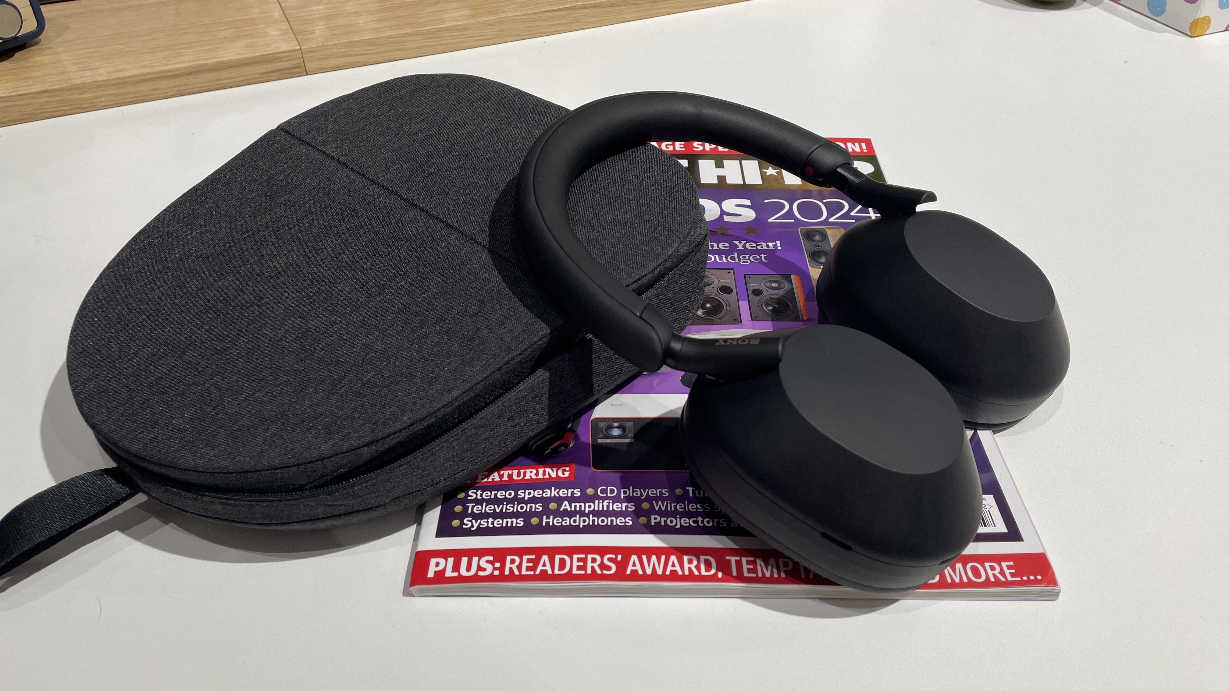 Sony WH-1000XM5 headphones next to their carry case