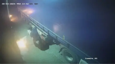 Metropolitan Police A man uses a fire extinguisher attempting to put out the fire burning alongside a lorry