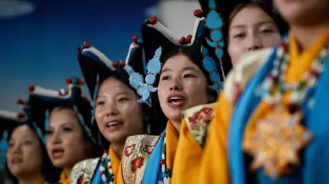 Reuters Tibetan girls in traditional attire including large pointed navy hats with sky blue adornments perform during birthday celebrations