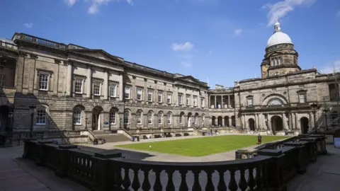 PA Media A courtyard surrounded by grey stone buildings, part of the University of Edinburgh