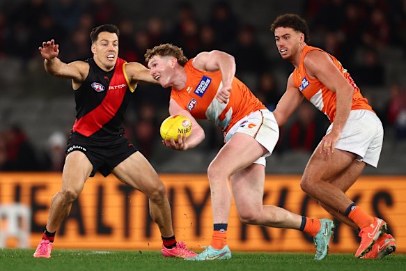 Tom Green of the Giants handballs against Essendon.