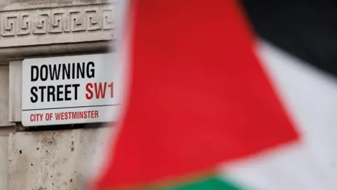 Getty Images  A Palestinian flag flies in front of a road sign reading Downing Street, SW1