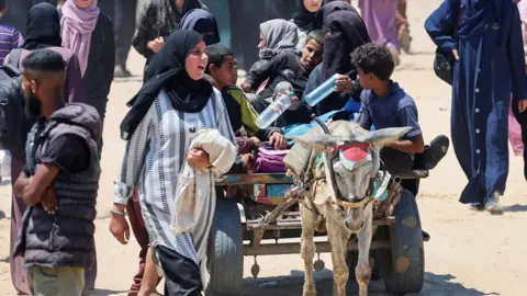 Reuters Palestinians seeking aid supplies from the US-backed Gaza Humanitarian Foundation travel in an animal-drawn cart, near Rafah, in southern Gaza (24 July 2025)