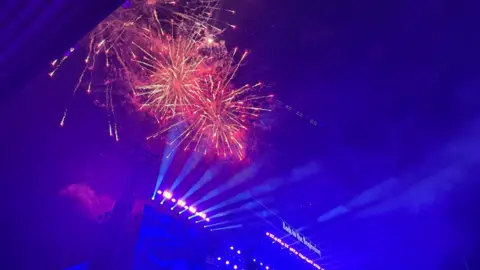 Red and yellow fireworks light up the stadium.