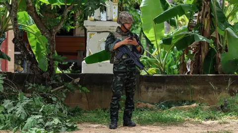 Anadolu via Getty Images A Thai soldier stands guard in the Surin province on the border with Cambodia. Photo: 25 July 2025