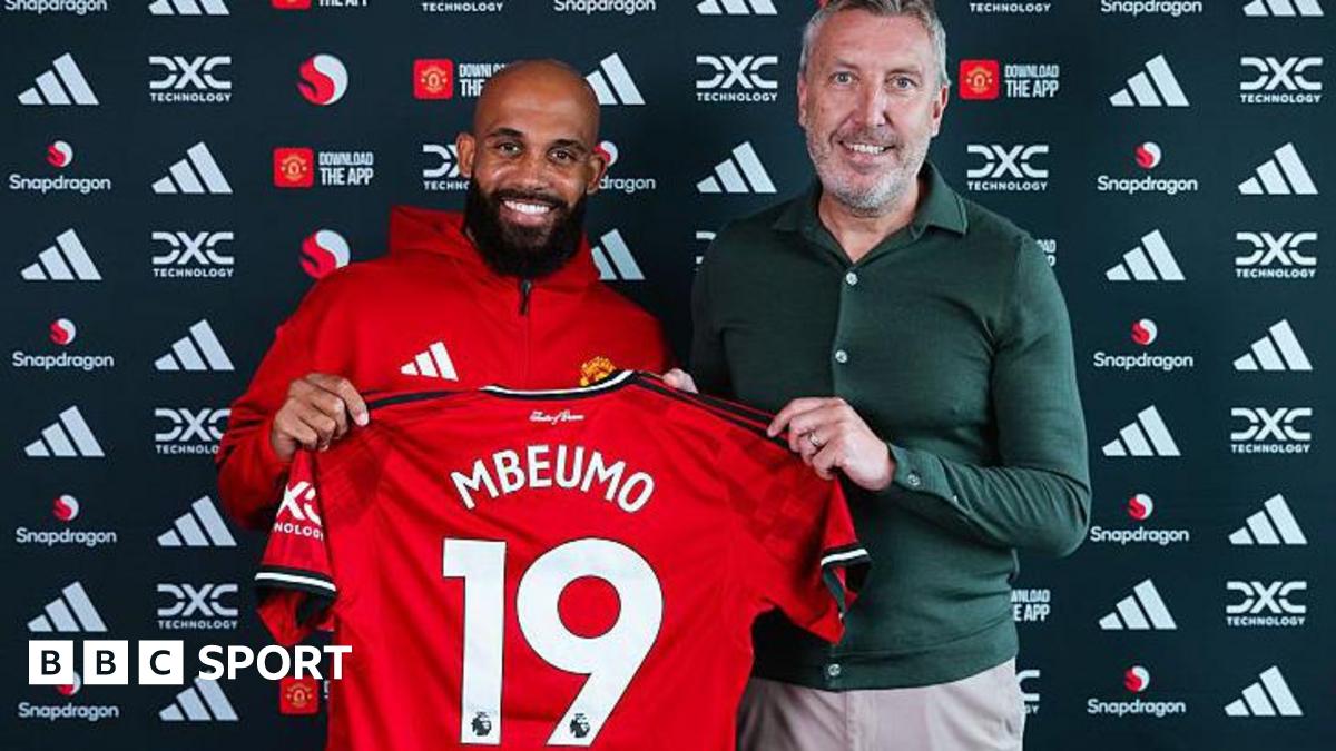 Bryan Mbeumo holding up a Manchester United shirt next to director of football Jason Wilcox.
