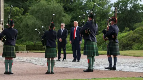 Reuters Donald Trump and Keir Starmer stand surrounded by bagpipers and greenery