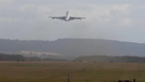 PA Media Air Force one just after take-off, flying into the distance