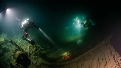 Steffen Scholz Divers explored the wreckage of HMS Nottingham with lights in the deep sea.
