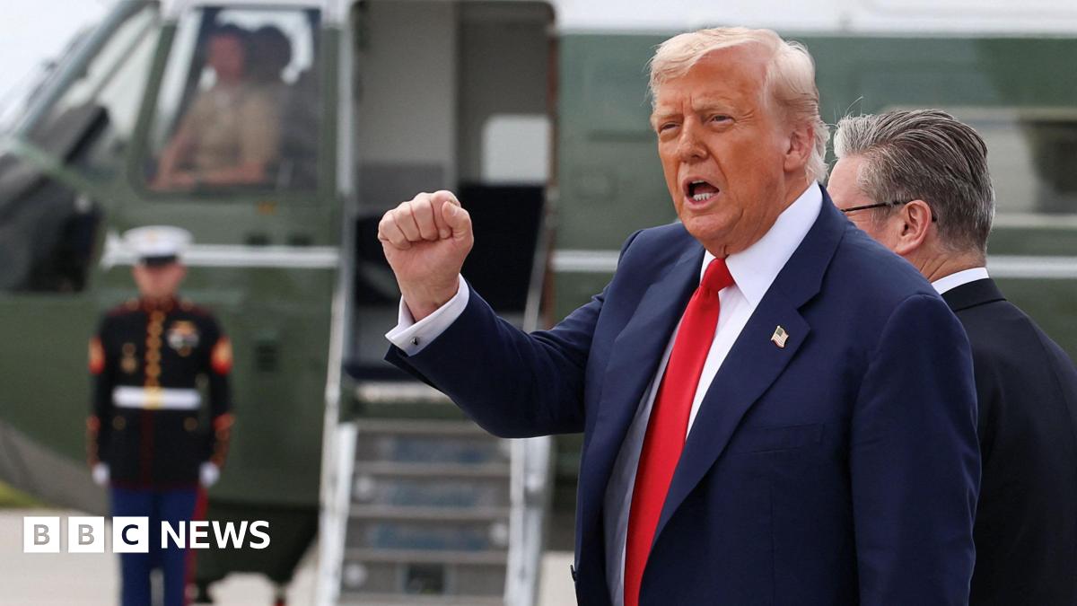 Donald trump ina suit and red tie pumps a fist in the air