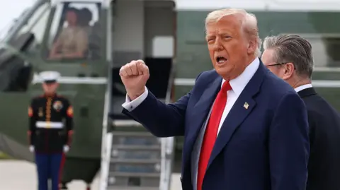 Reuters Donald trump ina suit and red tie pumps a fist in the air