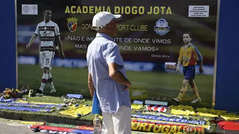 Getty Images A man stands in front of a memorial for Liverpool's Portuguese forward Diogo Jota, set up at the Gondomar Sport Clube's stadium