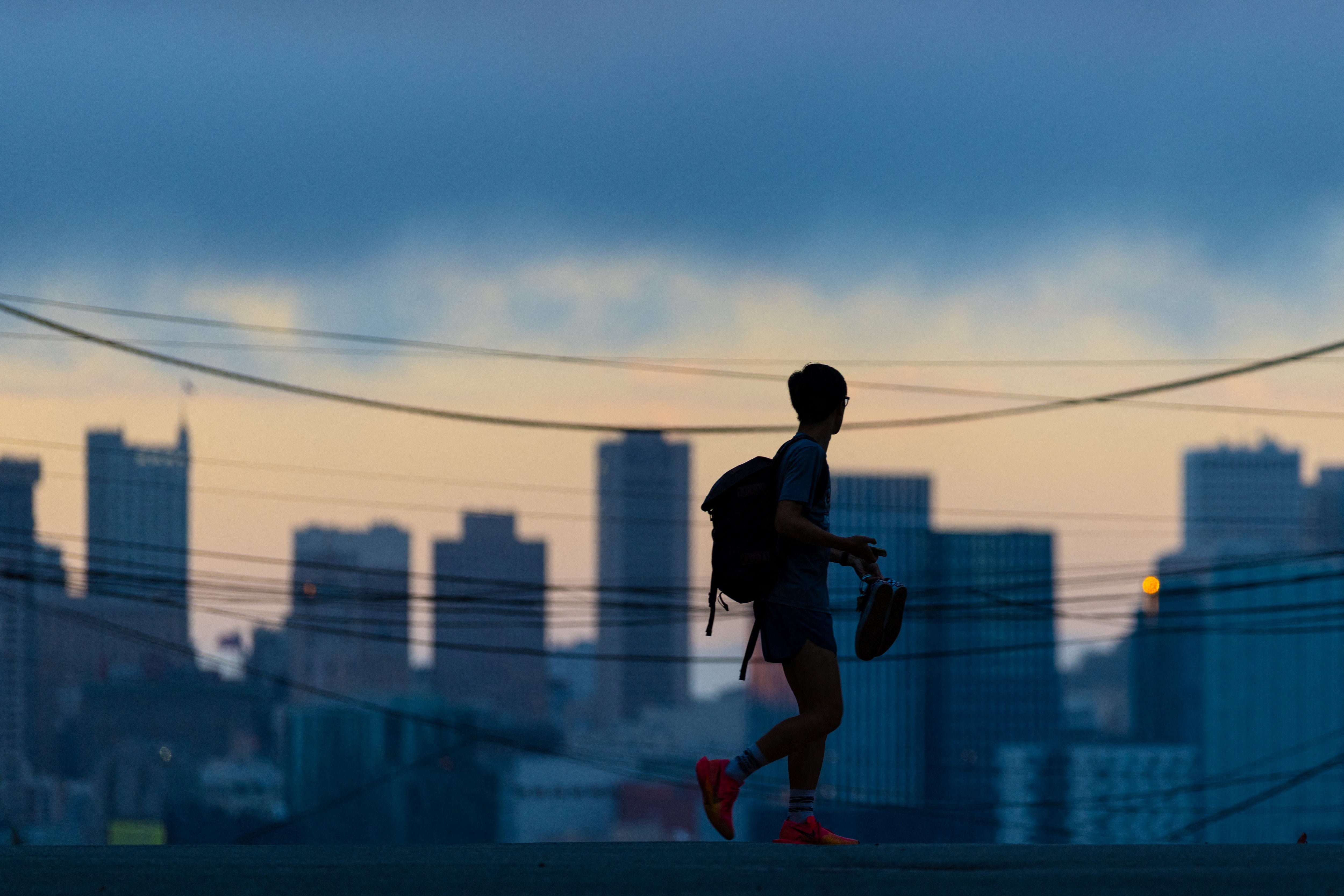 A person cross an empty street during sunset in San Francisco, California