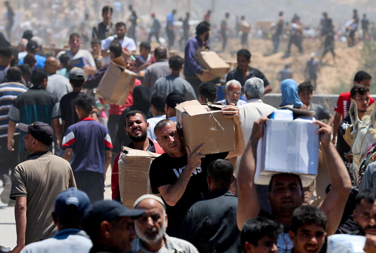 אזרחים פלשתינים בעזה מגיעים לקבל סיוע למרות קריאות חמאס להימנע מנקודות החלוקה , רויטרס