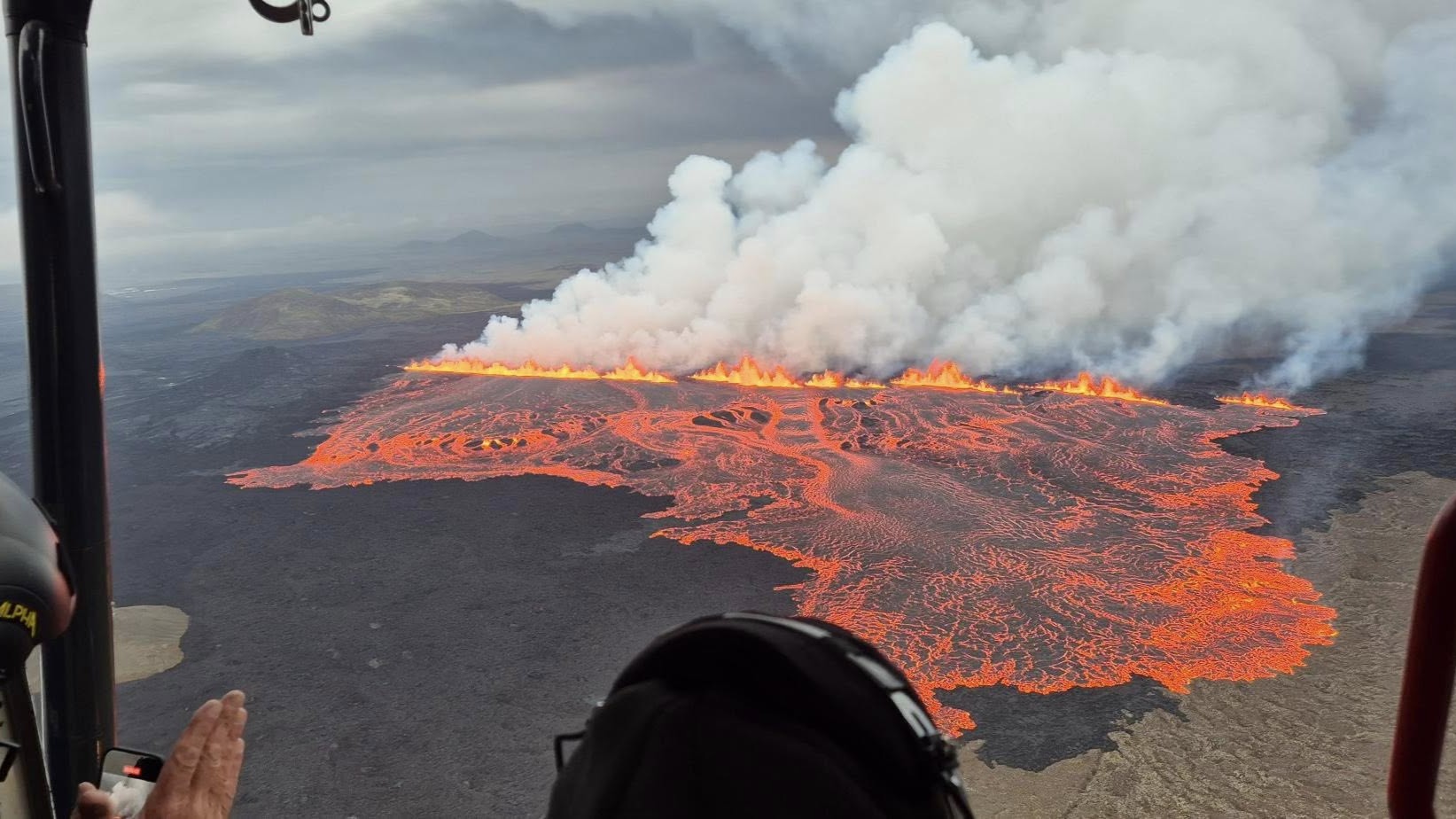 An aerial photograph of lava erupting from a fissure on Iceland's Sundhn&uacute;kur crater row.