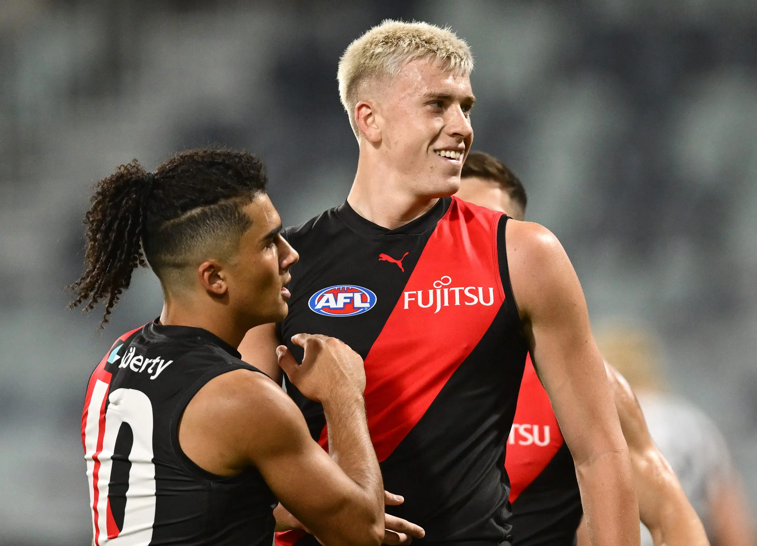 GEELONG, AUSTRALIA - FEBRUARY 25: Nate Caddy of the Bombers is congratulated by Isaac Kako of the Bombers after kicking a goal during the 2025 AAMI AFL Community Series match between Geelong Cats and Essendon Bombers at GMHBA Stadium on February 25, 2025 in Geelong, Australia. (Photo by Quinn Rooney/Getty Images)