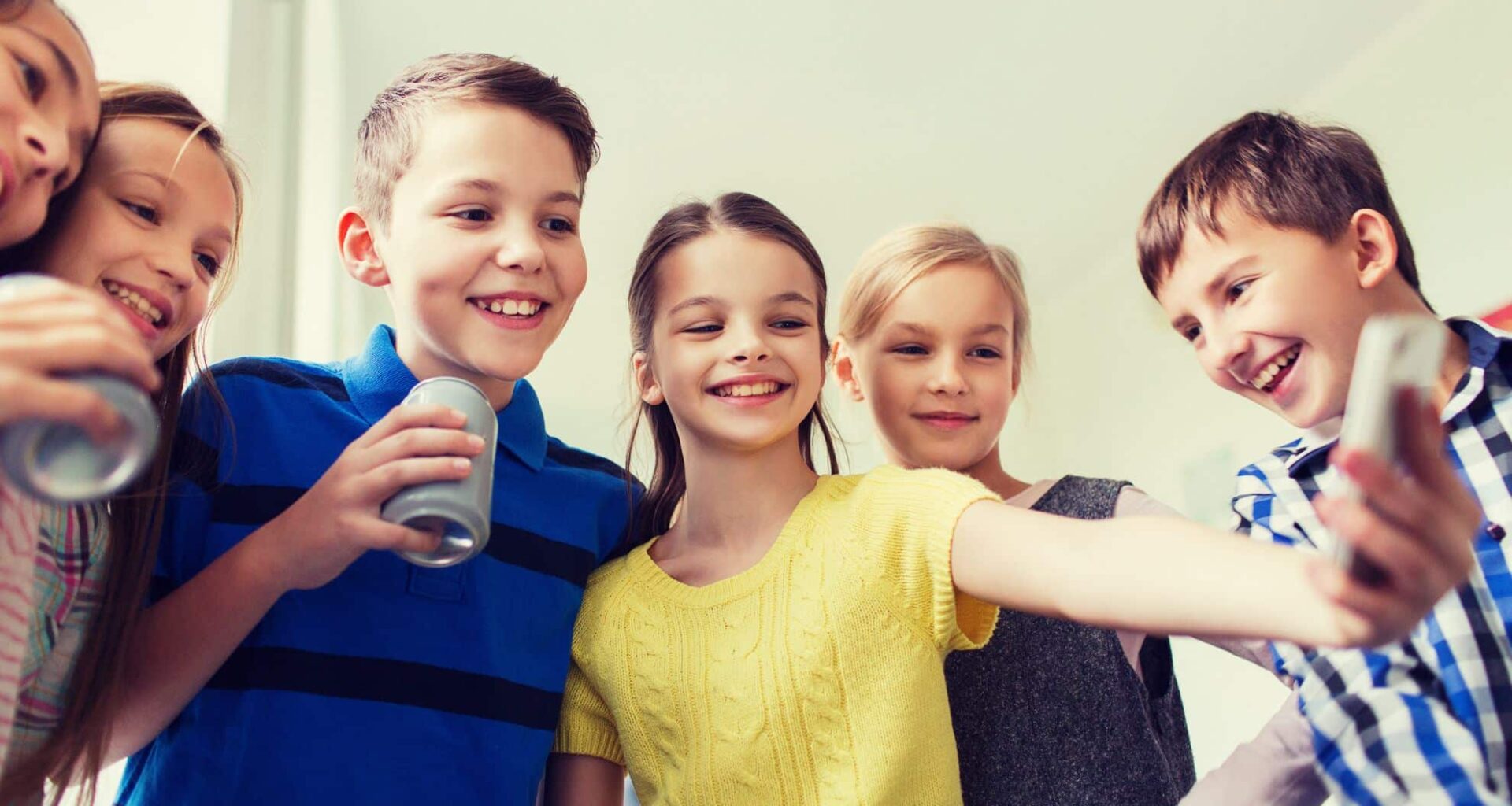 Group Of Schoolchildren With A Smartphone And Soda Cans Taking A Selfie