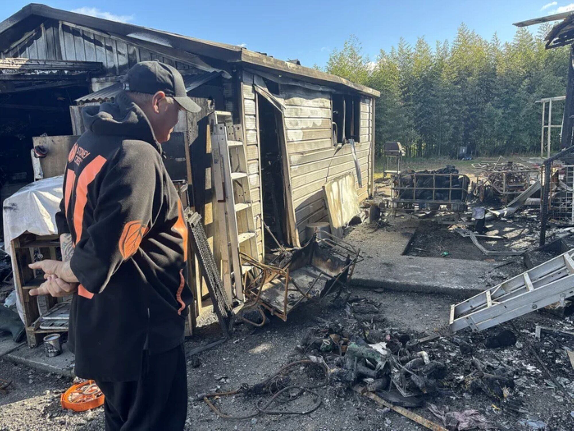 Ted Shortland surveys the damage to his property, including a pile of melted power tools and a trailer of firewood that never made it inside the house. Photo / Brianna Stewart