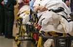 FILE - The state health authority estimates that between 100,000 and 200,000 Oregonians could lose Medicaid coverage as a result of these requirements. Gurneys line the hallway of the emergency department at Salem Health in Salem, Oregon in this Jan. 27, 2022 file photo.