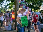 Protester Anna McClain holds a sign that reads “immigrants sustain America” during a “Good Trouble” protest nearby Laurelhurst Park in Portland, Ore., July 17, 2025. These “Good Trouble” demonstrations in various areas around Portland were part of a nationwide effort to protest against the Trump Administration in the name of the late congressman John Lewis of Georgia. 