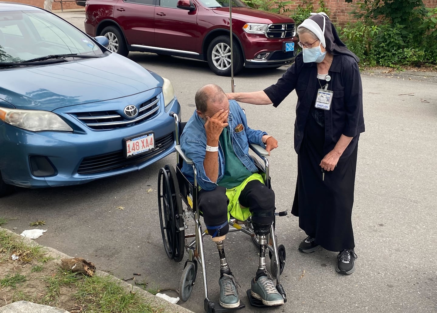 Michael Pimentel, who escaped the Fall River fire, is comforted by Sister Judith Costa, chaplain at St Anne’s Hospital, outside the Timao Center on Monday.