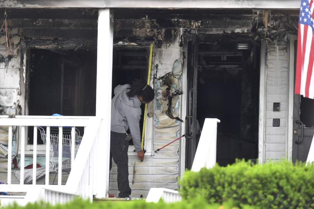 An investigator takes measurements Monday, July 14, 2025, near an entrance to the Gabriel House assisted living facility following a fire that started late Sunday in Fall River, Mass. (Steven Senne/AP)
