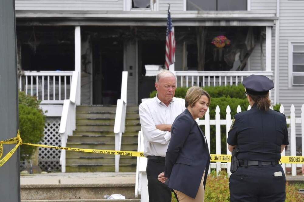 Massachusetts Gov. Maura Healey, center, and Fall River Mayor Paul Coogan, left, speak with a member of law enforcement, right, near the Gabriel House assisted living facility, Monday, July 14, 2025. (Steven Senne/AP)