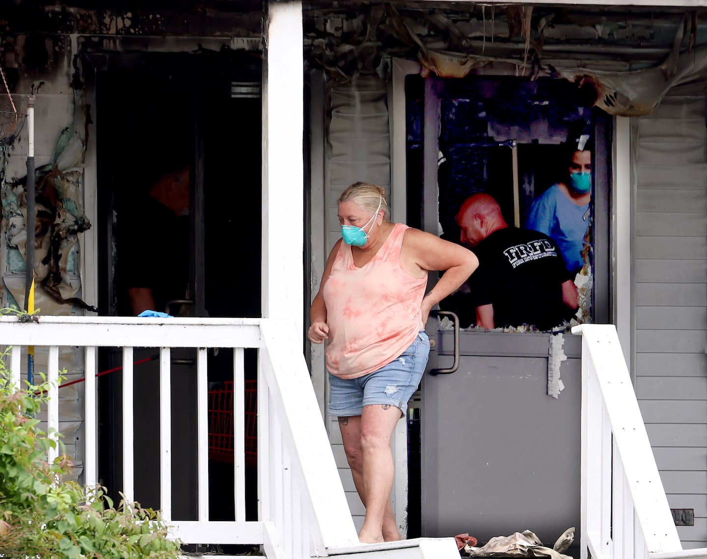A woman surveys damage at the entrance to the Gabriel House Assisted Living facility in Fall River Monday morning after a fire broke out Sunday night killing nine residents and injuring several others. 