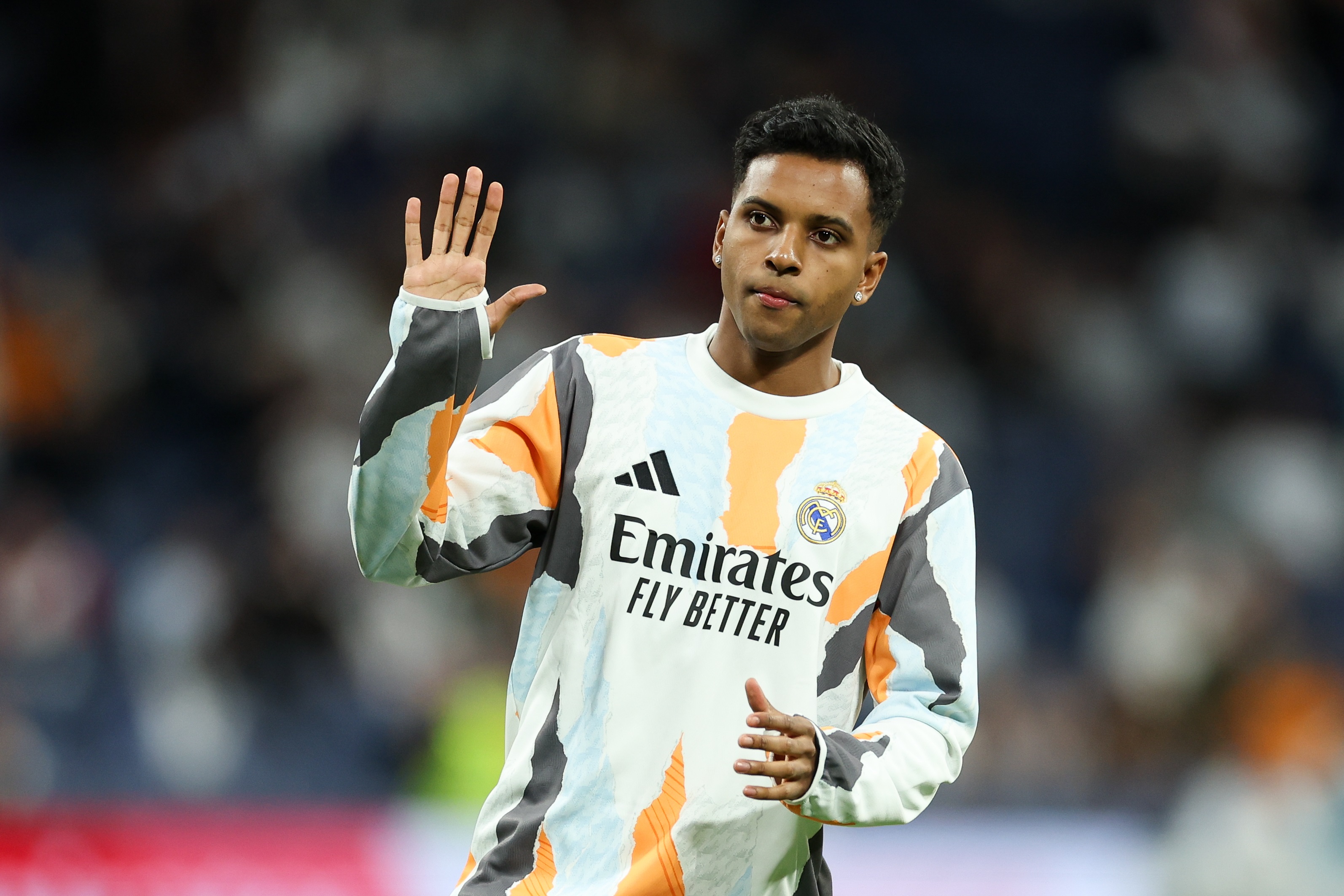 Rodrygo waves his hand during a warm up.