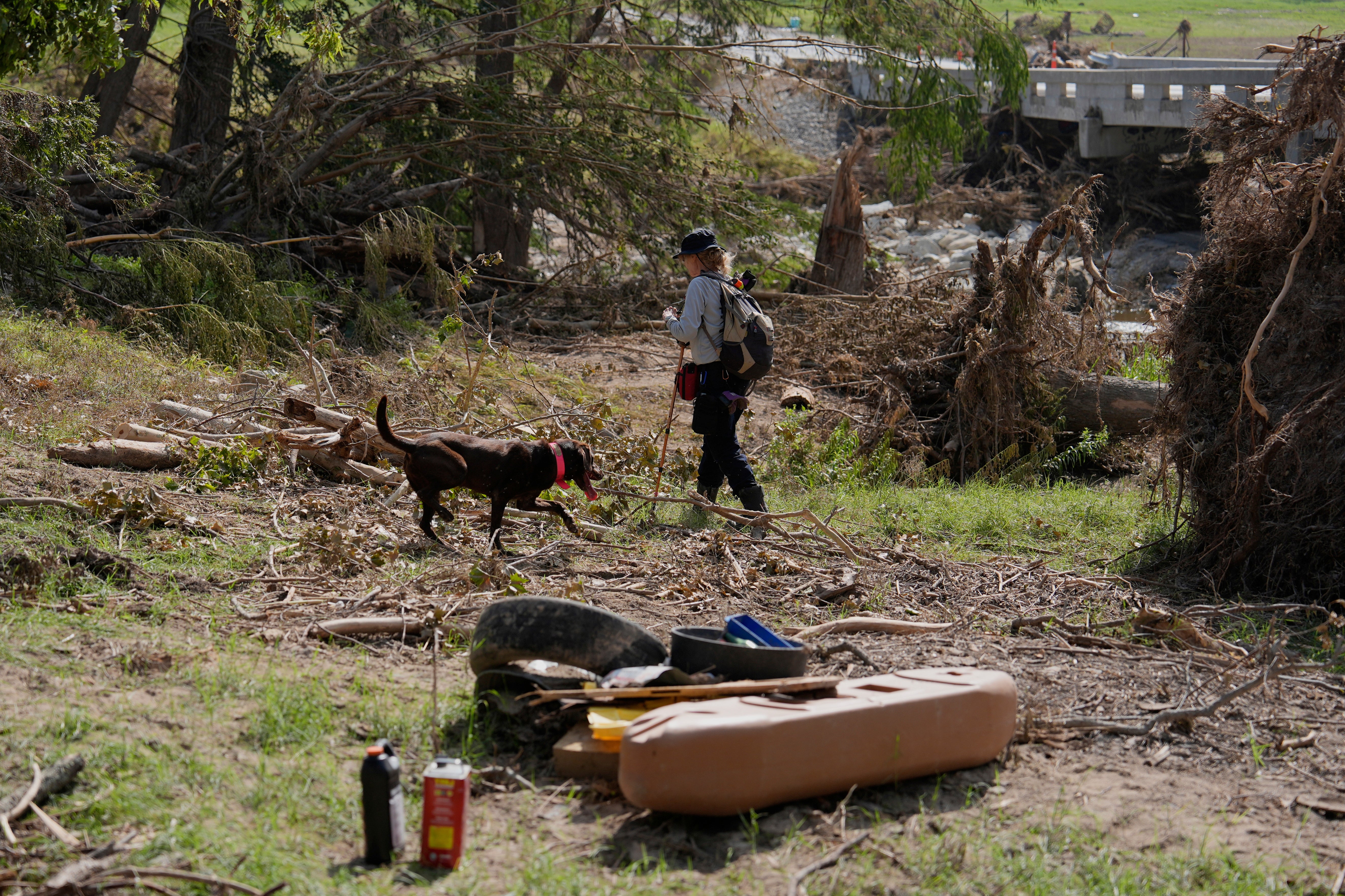 A rescue crew member searches for missing people with a dog in Kerr County. At least 120 people have died and more than 170 are missing