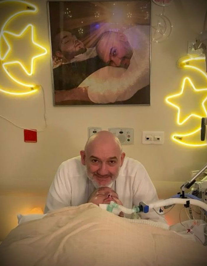 Man with a beard beside a bedridden patient on life support, symbolizing the sleeping prince of Saudi Arabia in coma.