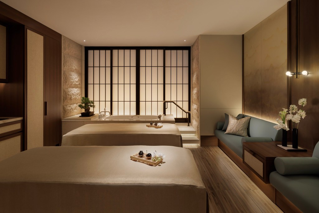 Serene spa room featuring two massage tables, a private soaking tub, soft lighting, and calming natural textures. Spa, Waldorf Astoria Osaka. Hilton