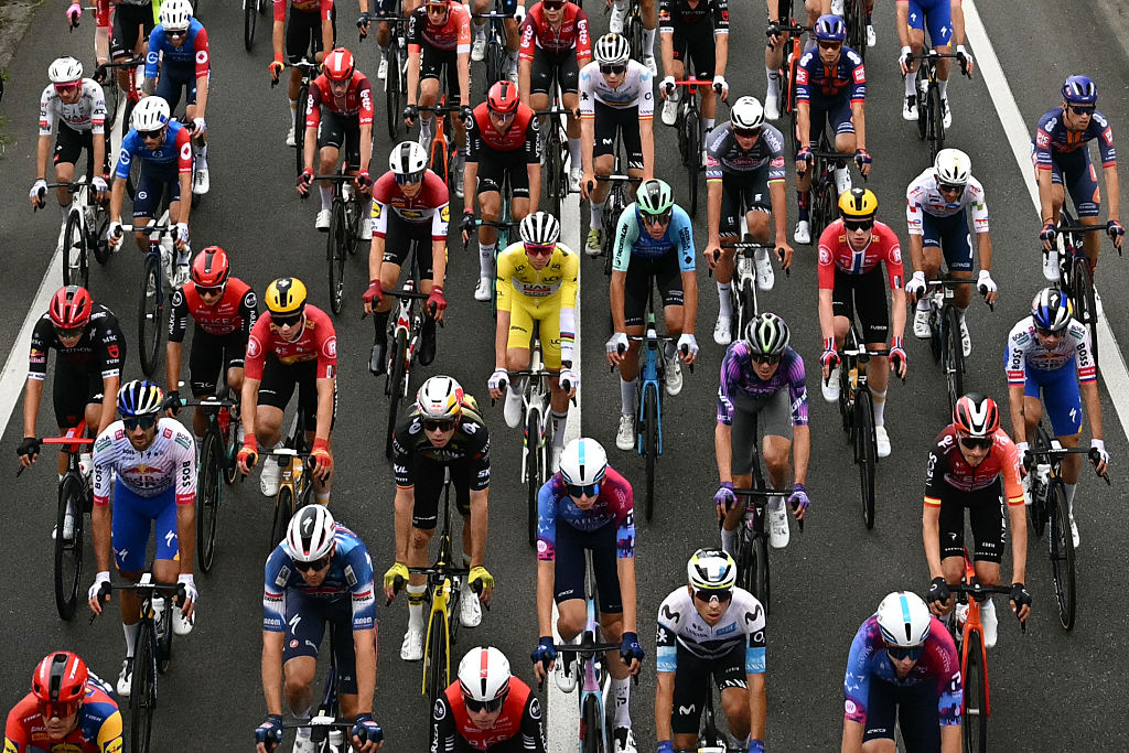 UAE Team Emirates - XRG team's Slovenian rider Tadej Pogacar wearing the overall leader's yellow jersey cycles with the pack of riders (peloton) cycles during the 14th stage of the 112th edition of the Tour de France cycling race, 182.6 km between Pau and Luchon-Superbagneres, in the Pyrenees mountains of southwestern France, on July 19, 2025. (Photo by Loic VENANCE / AFP)