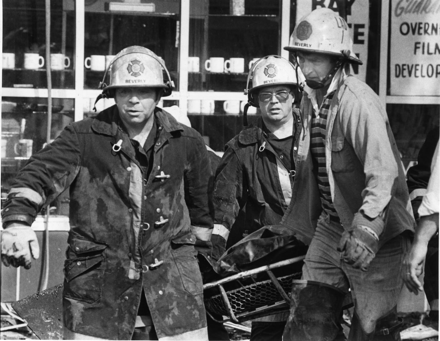 Beverly firefighters carry one of the dead from general alarm fire, that killed fifteen people. 