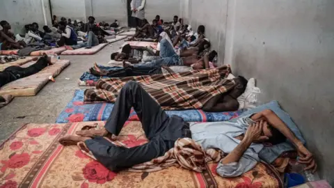 Getty Images Illegal immigrants are seen sleeping at a detention centre in Zawiyah, 45 kilometres west of the Libyan capital Tripoli, on June 17, 2017.