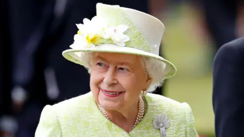 Getty Images Queen Elizabeth II in a green dress and hat in a photo from 2019