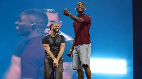 Getty Images Drake in black and Dave in red and blue
