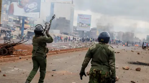 Getty Images Kenyan riot police, in uniform, use teargas to disperse the angry protesters at Waiyaki Way in Kangemi