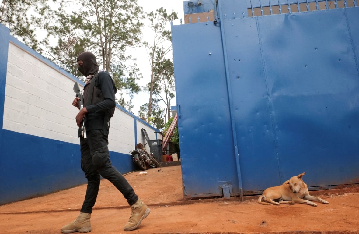 A neighbourhood watch member walks outside a police station in Furcy, Haiti.