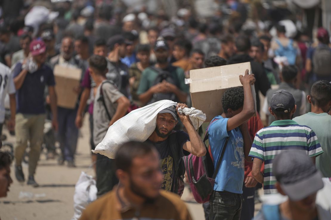 Palestinians carry boxes and bags containing food and humanitarian aid packages delivered by the Gaza Humanitarian Foundation on June 6.