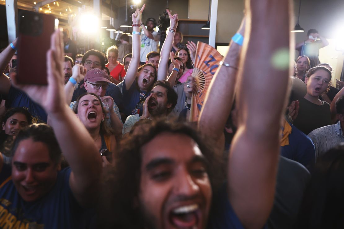 Mamdani supporters cheer before he takes the stage at his primary election night watch party.
