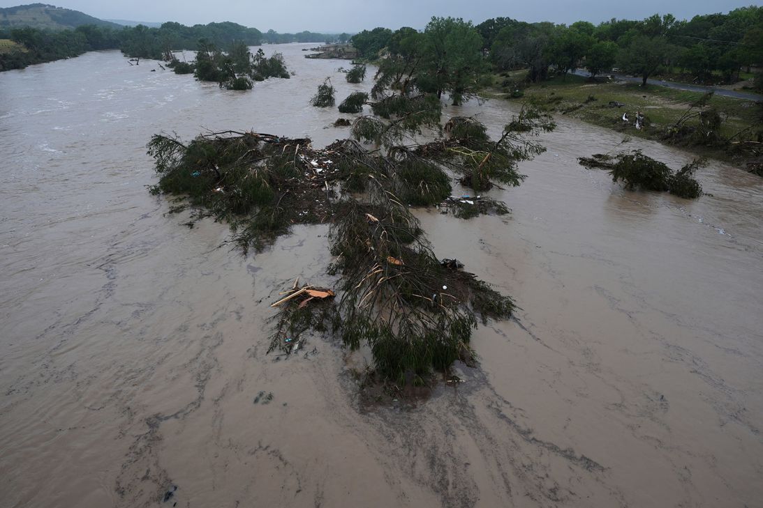 A raging Guadalupe River leaves fallen trees and debris in its wake on Friday in Kerrville, Texas.