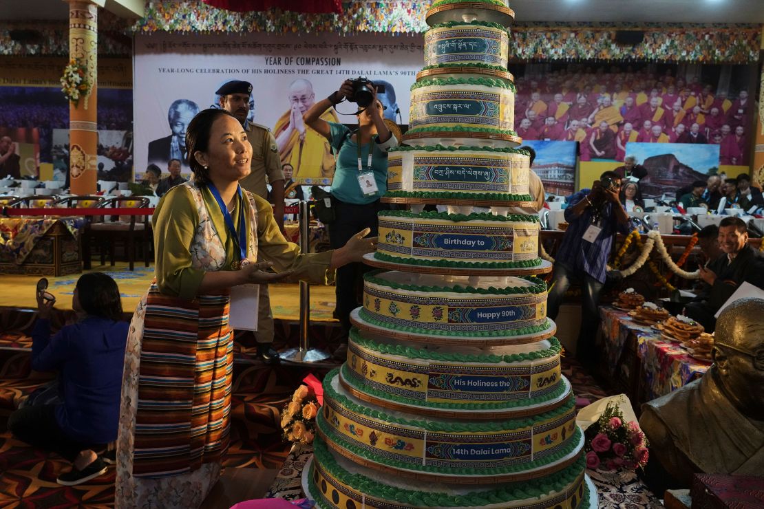 A devotee looks at a tall layered cake at the Dalai Lama's birthday celebration in  Dharamshala on Sunday.