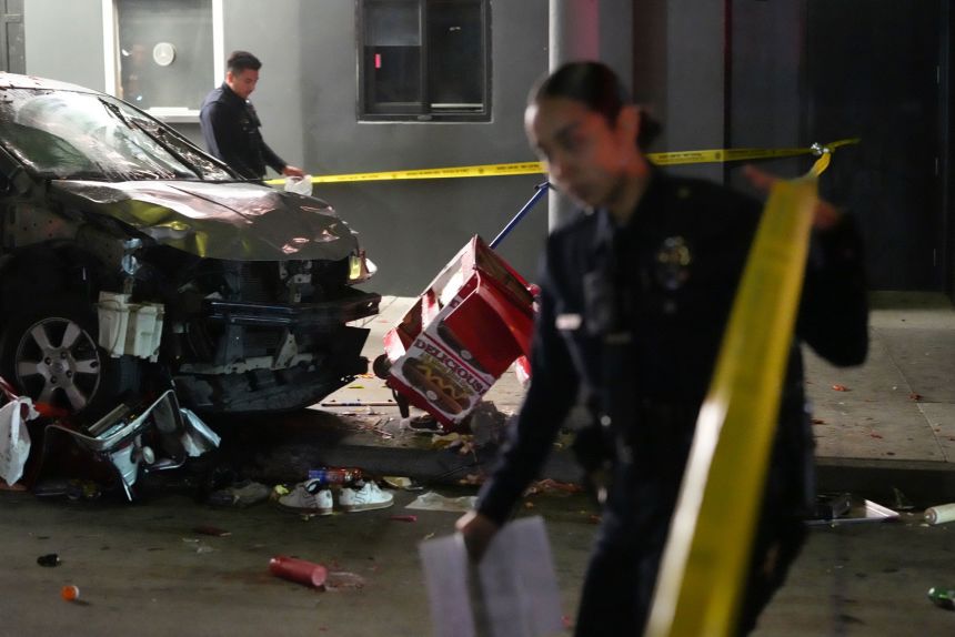 Law enforcement investigated the scene where a vehicle rammed into a crowd of people waiting to enter a nightclub along a busy boulevard in Los Angeles early Saturday.